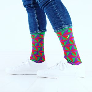 close up of person wearing green red and purple patterned socks